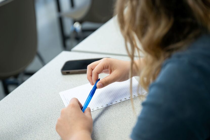 Etudiante qui tient un stylo en cours
